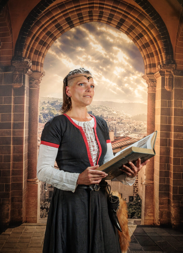Portrait en costume Renaissance avec un livre, dans le décor du studio de Raphaël Odin au Puy-en-Velay.